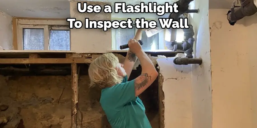 Use a Flashlight To Inspect the Wall