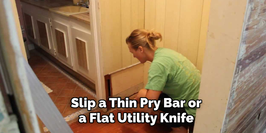 Slip a Thin Pry Bar or a Flat Utility Knife